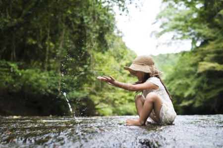 Photo for Little girl playing in the mountain stream - Royalty Free Image