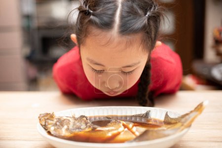 Téléchargez les photos : Enfant pour manger du poisson bouilli - en image libre de droit