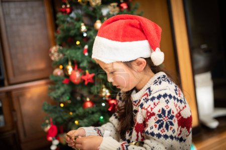 Téléchargez les photos : Fille pour décorer le sapin de Noël - en image libre de droit
