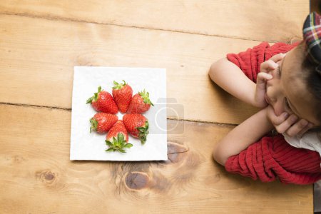 Téléchargez les photos : Fraises sur assiette et petite fille - en image libre de droit