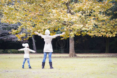 Téléchargez les photos : Mère et fille jouant dans le parc d'automne - en image libre de droit