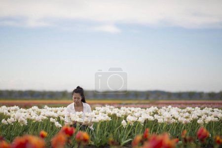 Photo for Woman relaxing in the tulip field - Royalty Free Image
