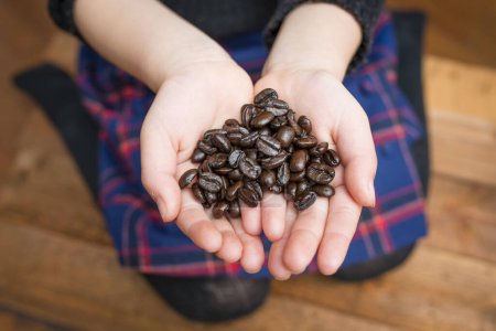 Manos de niño con granos de café