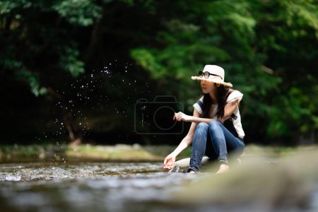 Téléchargez les photos : Femme japonaise se détendre au bord de la rivière - en image libre de droit