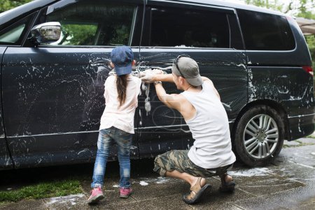 Photo for Father and daughter washing the car - Royalty Free Image