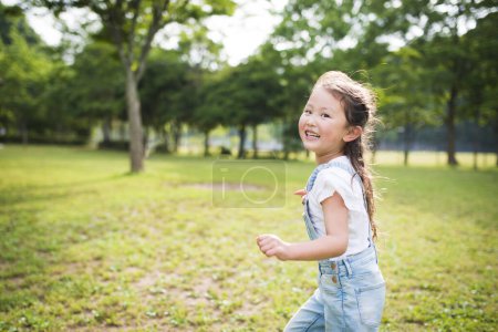 Téléchargez les photos : Bonne petite fille courir avec un sourire - en image libre de droit
