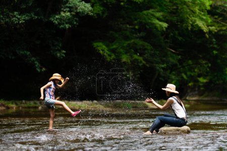 Foto de Madre e hija jugando en el arroyo de la montaña - Imagen libre de derechos