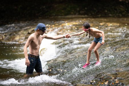 Père et fille jouant dans le ruisseau de montagne