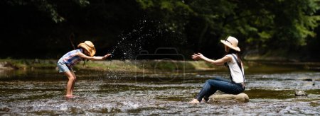 Foto de Madre e hija jugando en el arroyo de la montaña - Imagen libre de derechos