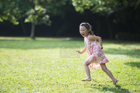 Photo for Happy Little Girl running in the meadow - Royalty Free Image