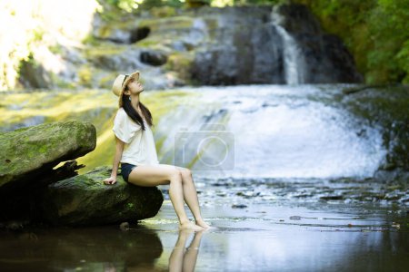 Téléchargez les photos : Une femme se relaxant dans un ruisseau de montagne - en image libre de droit