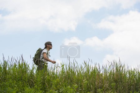 Téléchargez les photos : Homme marchant dans la prairie - en image libre de droit