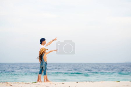 Téléchargez les photos : Père avec petite fille sur la plage de sable fin - en image libre de droit