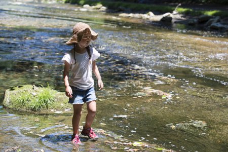 Happy little girl playing in Mountain stream