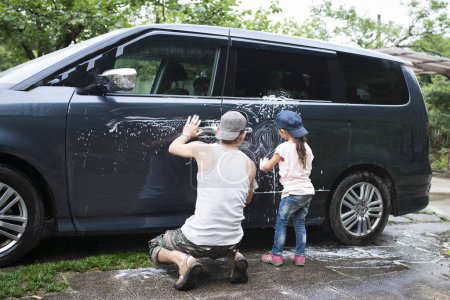 Téléchargez les photos : Père et fille lavent la voiture - en image libre de droit