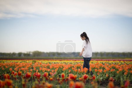 Foto de Mujer relajándose en los campos de tulipanes - Imagen libre de derechos