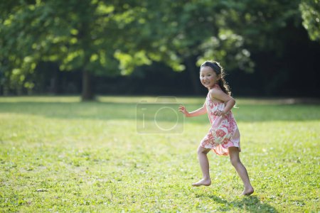 Photo for Happy Little Girl running in the meadow - Royalty Free Image