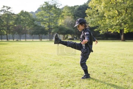 Photo for Little girl who kicks in police costume - Royalty Free Image