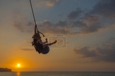 Téléchargez les photos : Petite fille jouant à la plage du coucher du soleil - en image libre de droit