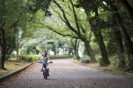 Photo for Little girl riding a bicycle in park - Royalty Free Image