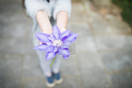 Téléchargez les photos : Petite fille tenant fleur bleue - en image libre de droit