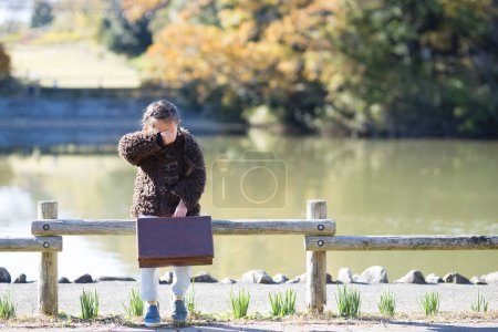 Téléchargez les photos : Petite fille avec un sac près de la rivière - en image libre de droit