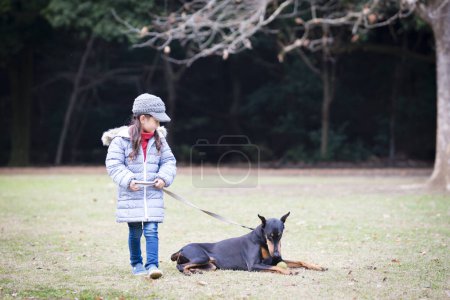 Photo for Girl taking a walk with Doberman - Royalty Free Image