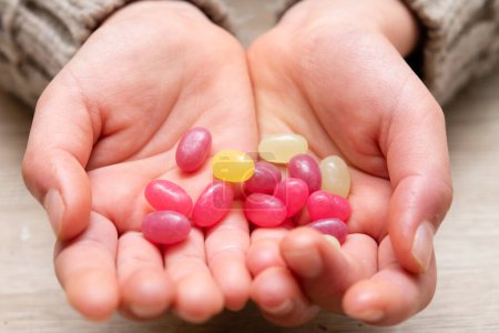 Photo for Child's hands holding colorful candies - Royalty Free Image