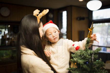 Foto de Madre e hija decorando el árbol de Navidad - Imagen libre de derechos