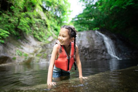 Téléchargez les photos : Petite fille jouant dans le ruisseau de montagne - en image libre de droit