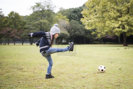 Foto de Niña pateando una pelota de fútbol - Imagen libre de derechos
