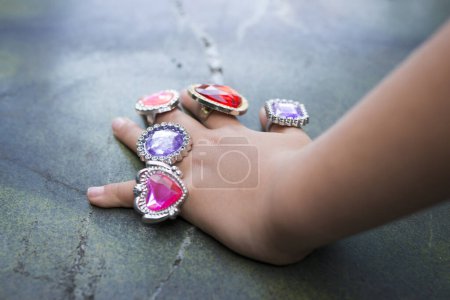 Photo for Children's hand with a lot of toy rings - Royalty Free Image