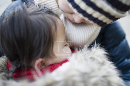 Téléchargez les photos : Petite fille qui fait une sieste dans les bras de sa mère - en image libre de droit