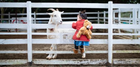 Téléchargez les photos : Fille avec une chèvre dans la ferme - en image libre de droit