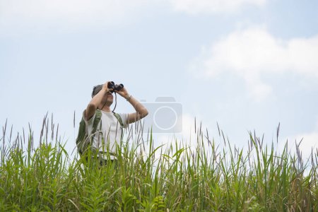 Photo for A man looking far away with binoculars - Royalty Free Image