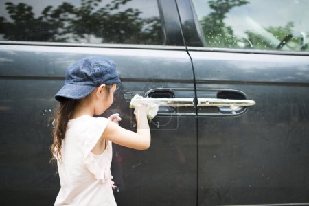 Photo for Little girl washing a car - Royalty Free Image