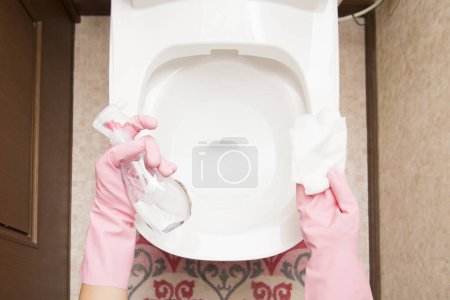 Téléchargez les photos : Personne nettoyant les toilettes blanches - en image libre de droit