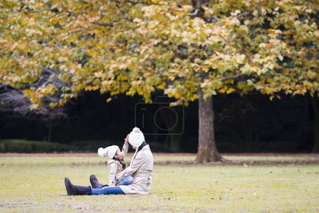 Photo for Mother and daughter playing in autumn park - Royalty Free Image