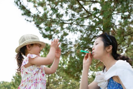 Mother and daughter playing with soap bubbles