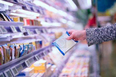 Téléchargez les photos : Femme choix de fromage à la main au supermarché - en image libre de droit