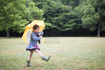Photo for Girl walking with an umbrella on a rainy day - Royalty Free Image