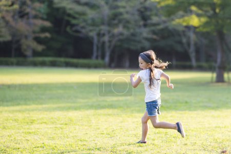 Foto de Chica corriendo en el césped en el parque - Imagen libre de derechos