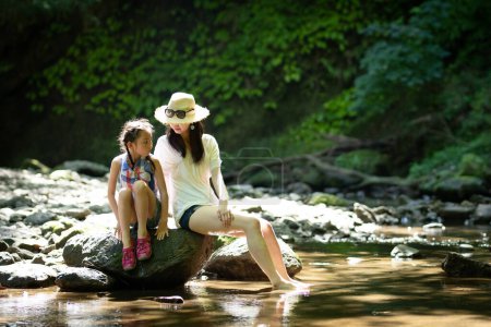 Téléchargez les photos : Mère et fille jouant dans le ruisseau de montagne - en image libre de droit