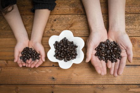 Parent and child hands with coffee beans