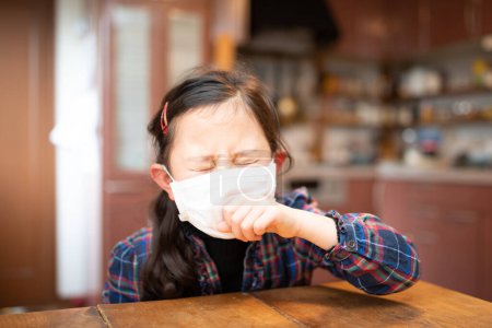 Girl coughing wearing a mask