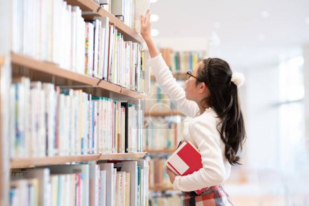 Photo for Asian  student choosing  book in library - Royalty Free Image