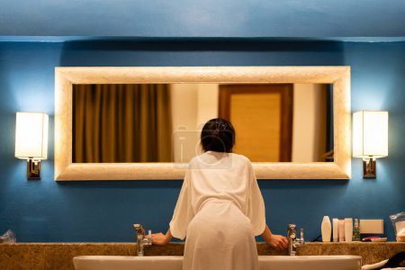 Téléchargez les photos : Une femme s'habillant devant le miroir - en image libre de droit
