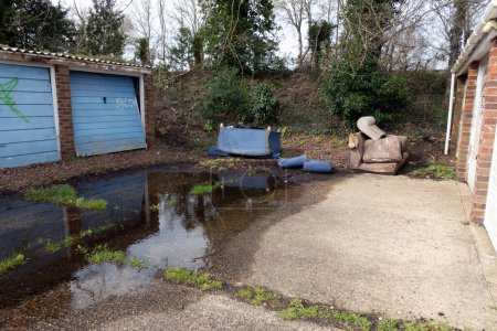 A Abandoned and Dumped Sofa Armchair at the Garages Flytipped in the Rain