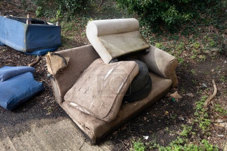Ein verlassener und umgeworfener Sofa-Sessel in der Garage kippte im Regen um