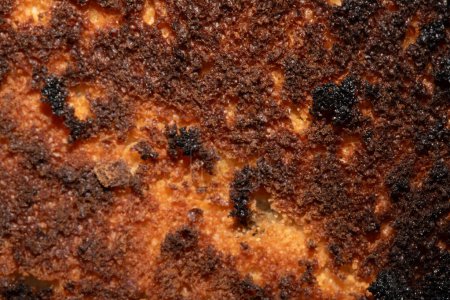Eine sehr verbrannte Brotrolle Toast in Nahaufnahme Textur